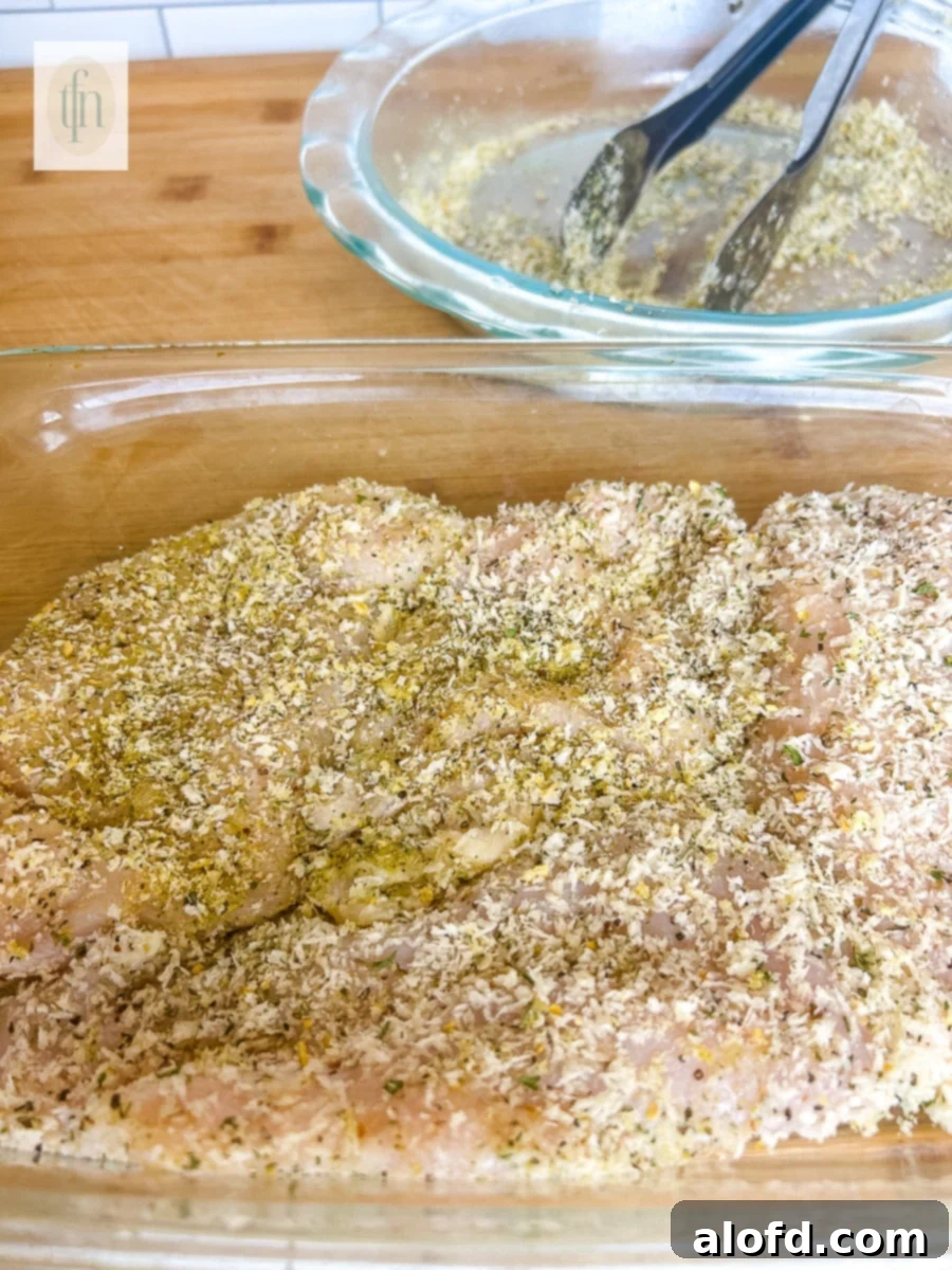 Golden Panko-Crusted Chicken Breast 6 A boneless, skinless piece of panko crusted chicken in a dish, ready for cooking.