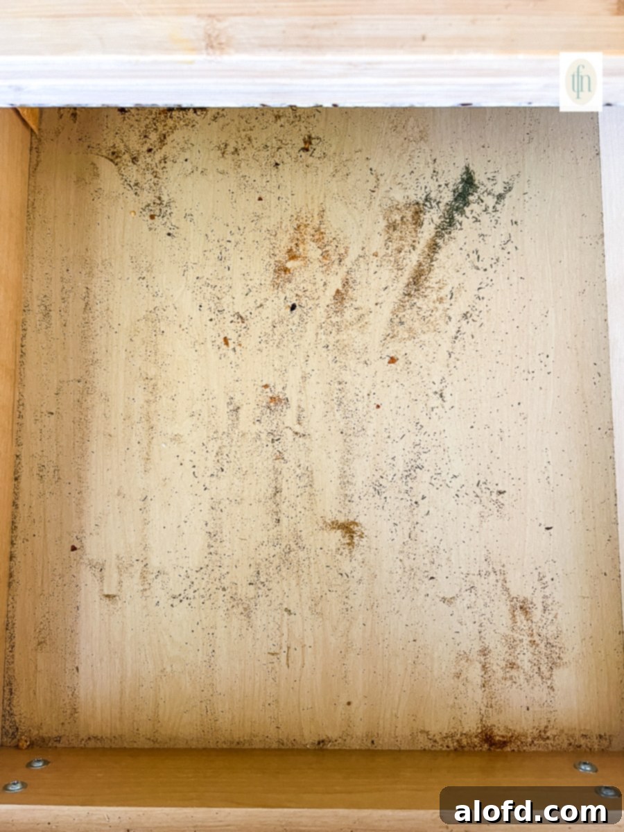 Dirty kitchen drawer filled with particles of spices that have gone bad.