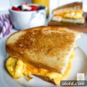 Tangy Sourdough Morning Stack 12 One half of a sourdough breakfast sandwich on a small plate, showing the layers.