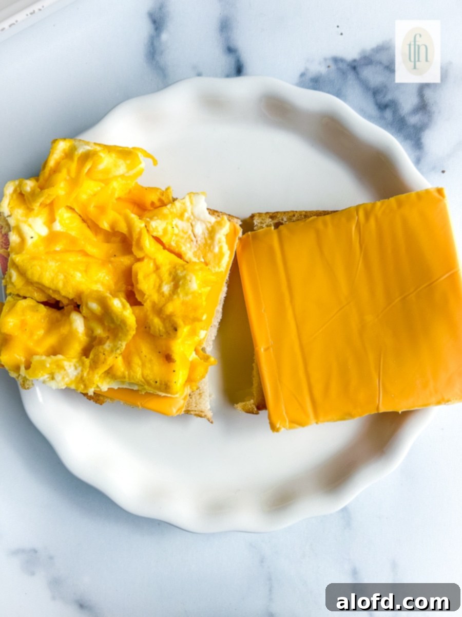 Tangy Sourdough Morning Stack 9 Open faced sourdough breakfast sandwich with scrambled eggs and American cheese before toasting.