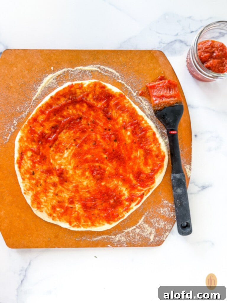 Ultimate Neapolitan Pizza Dough 2 Neapolitan pizza dough brushed with pizza sauce.