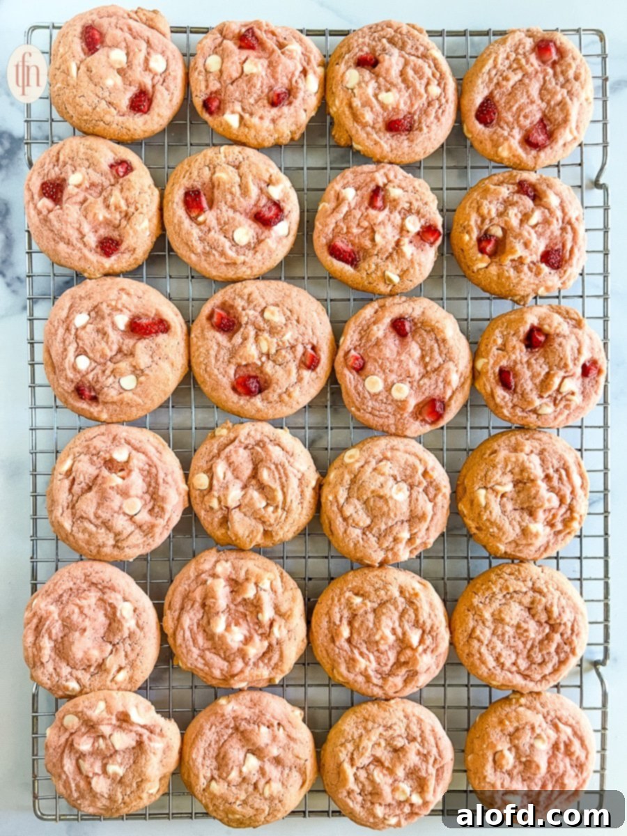 Strawberry Cheesecake Cookie Bliss 2 Cooling rack of baked strawberry cheesecake cookies, glistening with berry goodness.