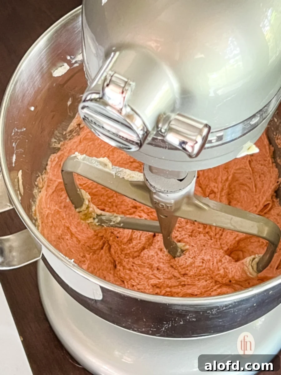 Strawberry Cheesecake Cookie Bliss 7 Making a strawberry cookie recipe in the bowl of a KitchenAid stand mixer, showing dough coming together.