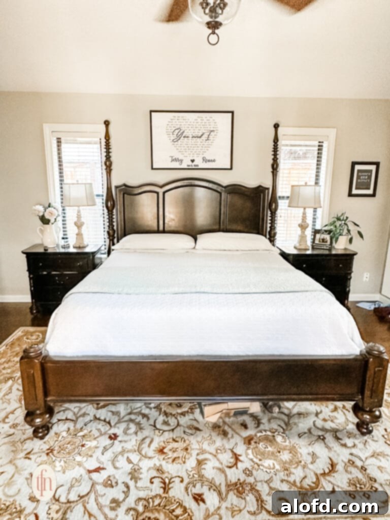 A partially unmade bed showcasing beautiful layers, situated in a spacious bedroom with elegant nightstands and lamps.