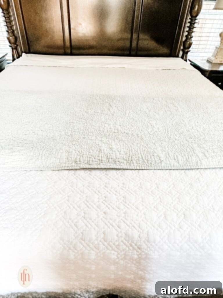 A pristine white quilt demonstrating the elegant effect of carefully layered bedding.