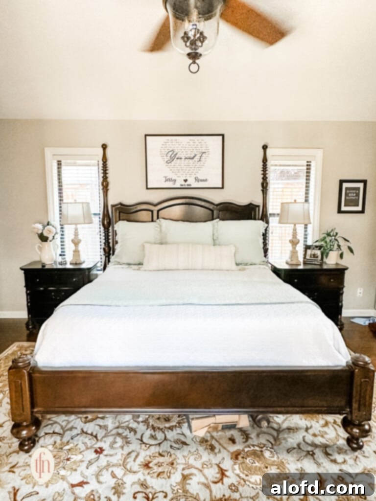A meticulously designed queen-sized bed, showcasing the perfect arrangement of layered bedding and decorative pillows.