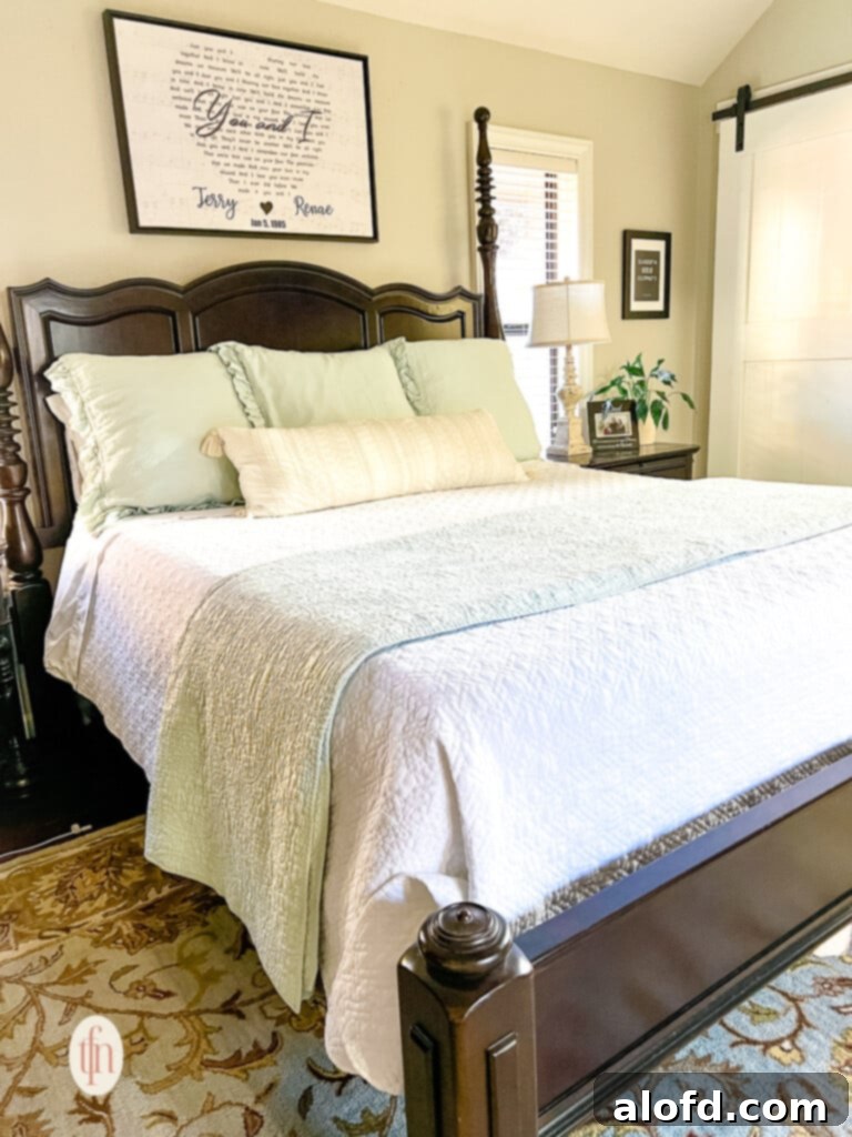 A queen-sized bed meticulously dressed with layers of designer bedding, showcasing a sophisticated arrangement.