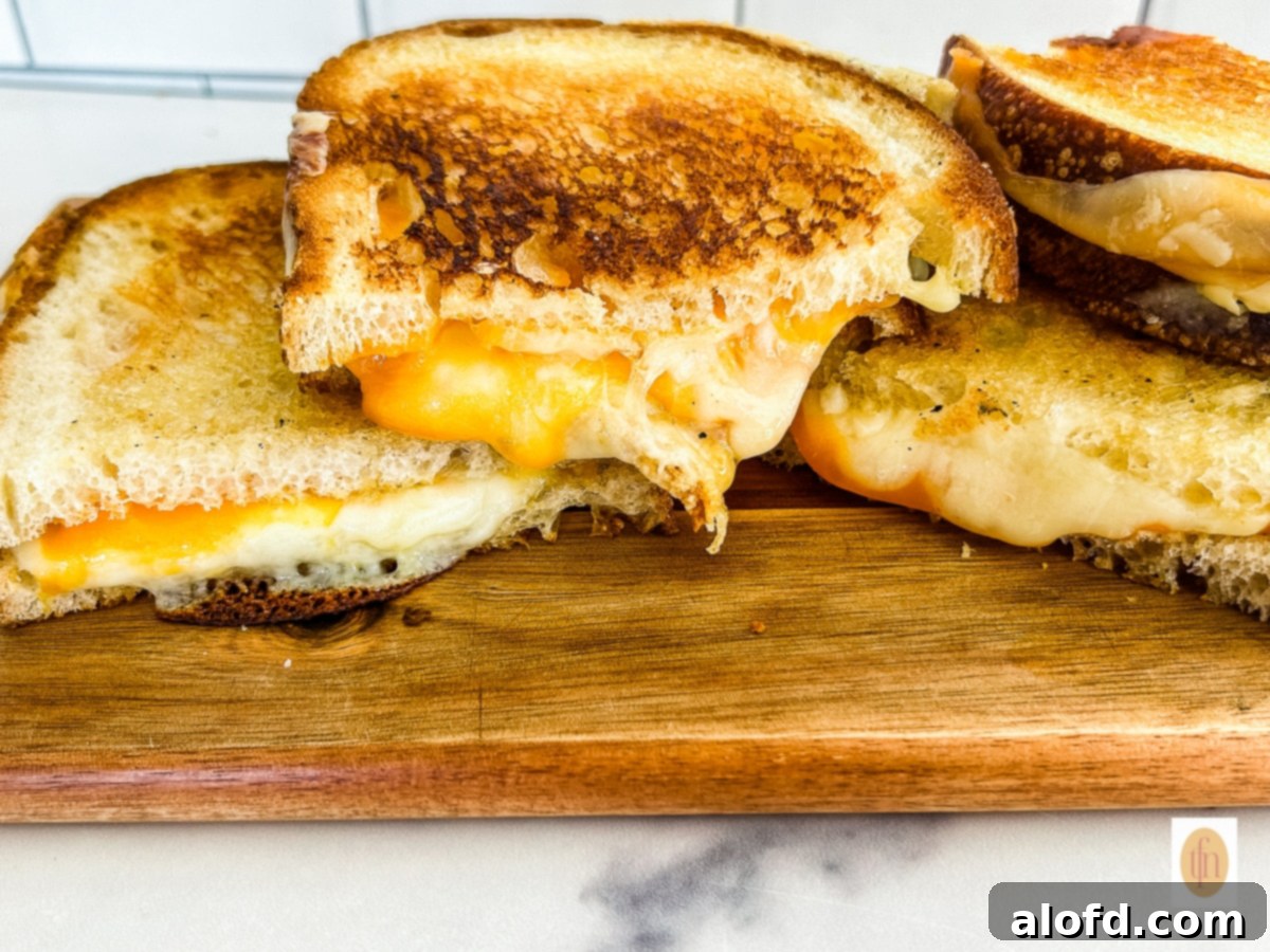 Tangy Sourdough Golden Cheese Melt 8 Perfectly toasted sourdough grilled cheese, cut in half diagonally, presented on a rustic wood serving platter.