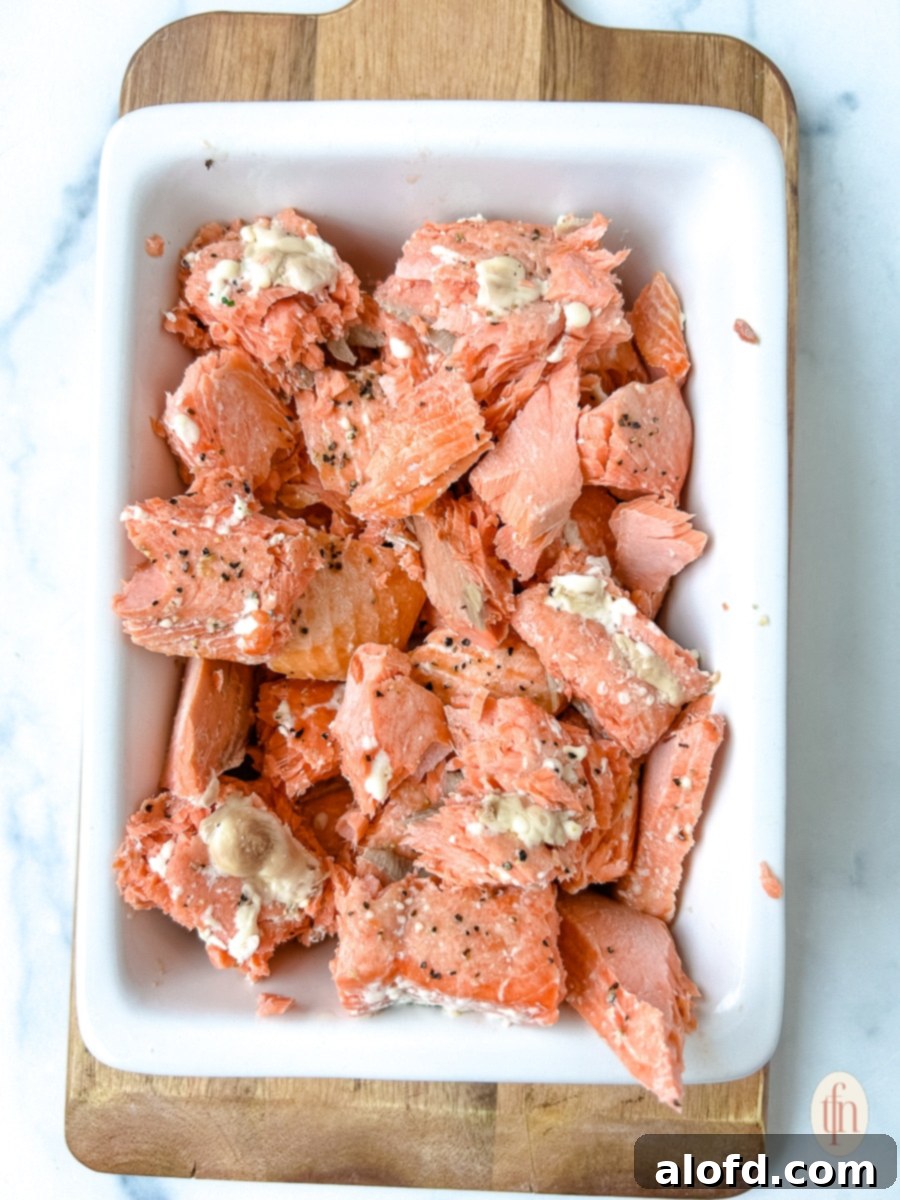 Decadent Salmon Alfredo 6 Flaked pieces of baked Italian salmon artfully arranged in a serving dish, ready to be incorporated into the creamy Alfredo pasta.