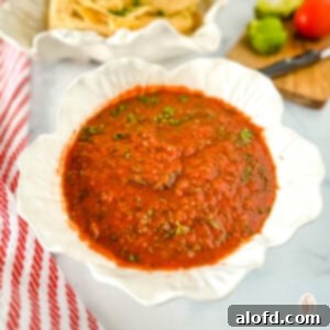 Small white dish of jalapeno salsa, showcasing its fresh and vibrant appearance.