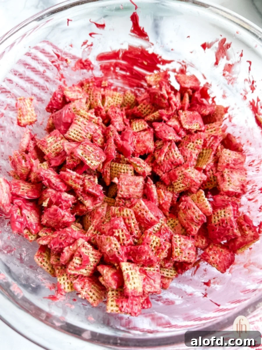 Festive Muddy Buddies 8 Red coated cereal in a glass bowl.