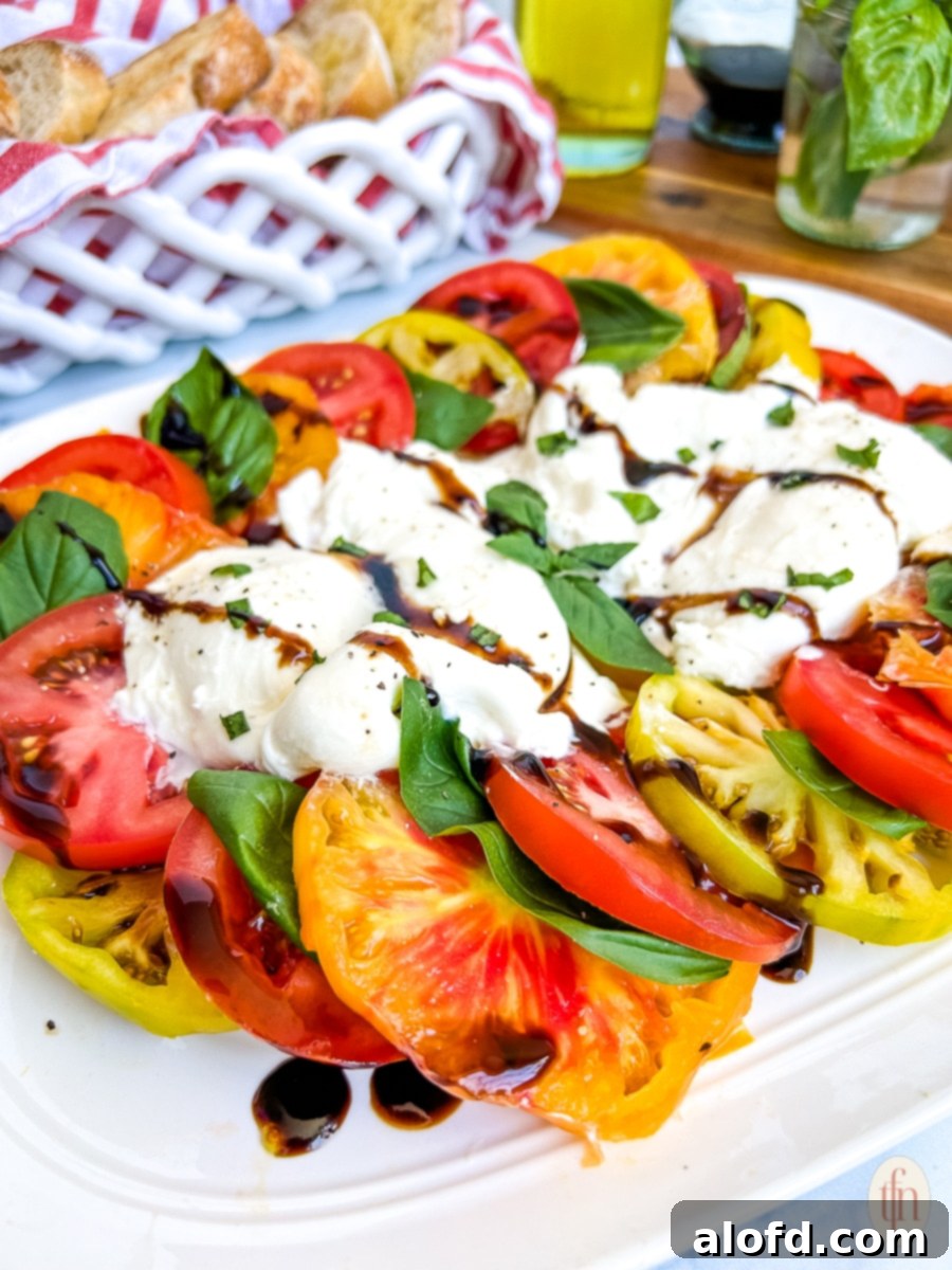 Tomato salad with burrata cheese and drizzle of balsamic vinegar.