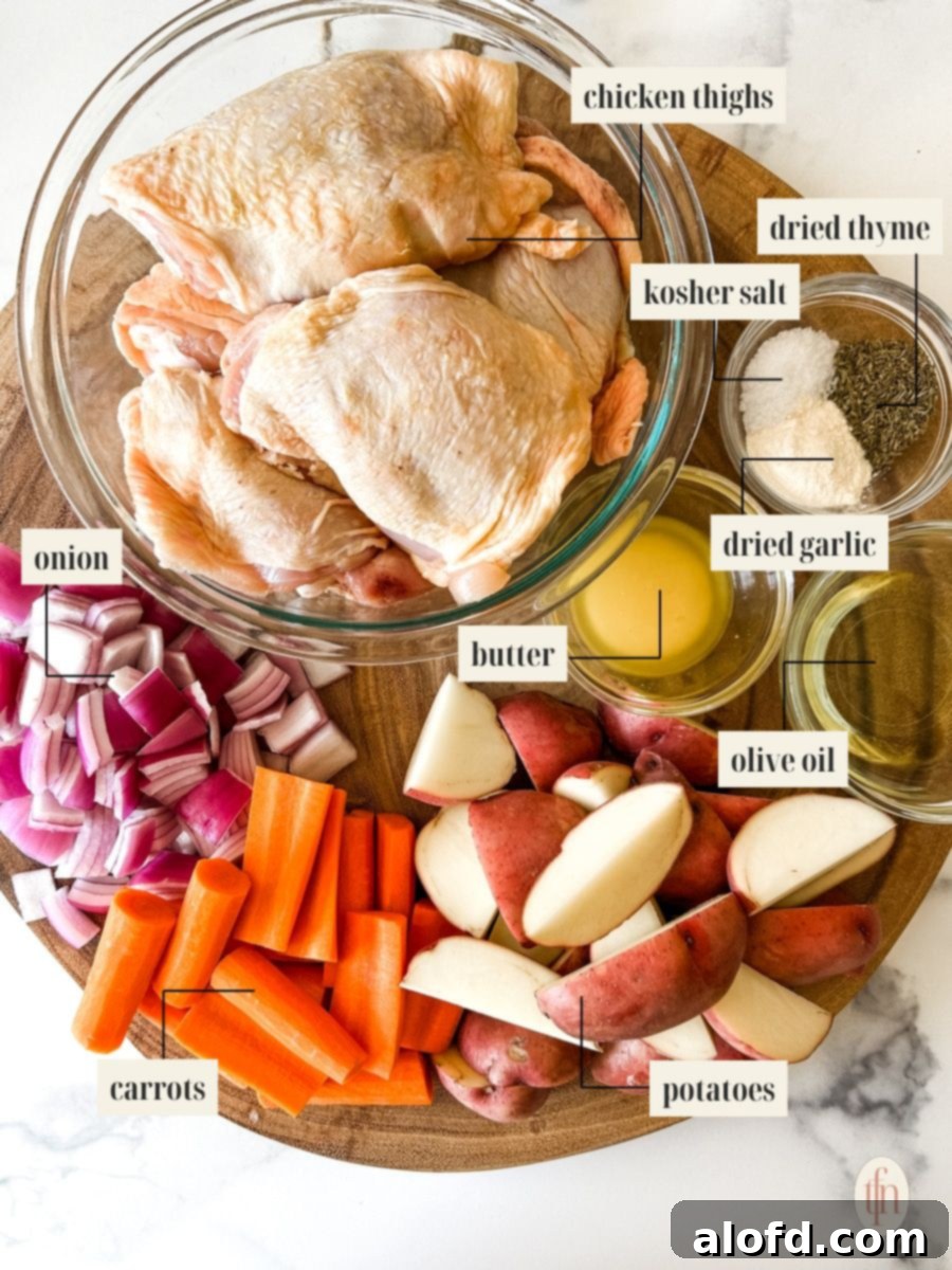 A well-organized spread of fresh ingredients for sheet pan chicken thighs and vegetables, including raw chicken, potatoes, carrots, onions, and seasonings, all clearly labeled.