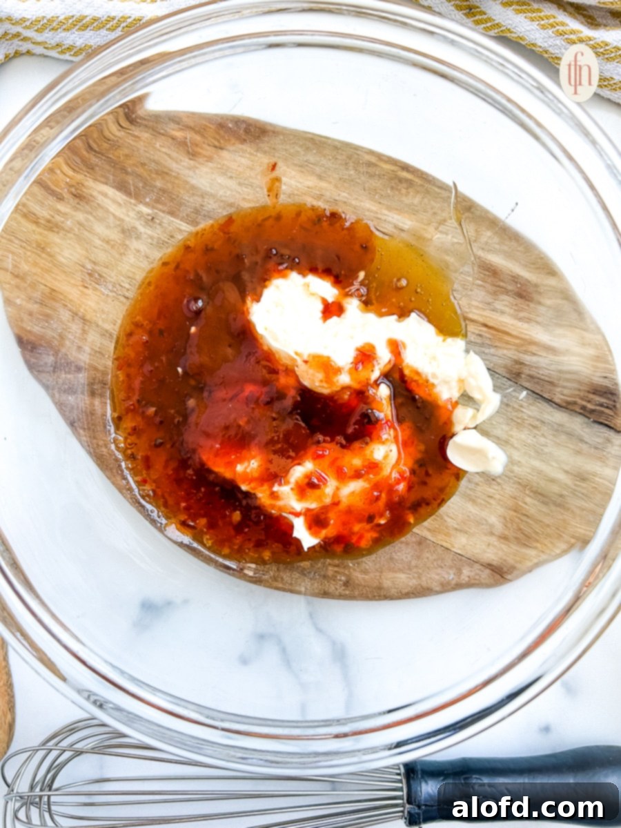 Dynamite Sweet Chili Sauce 6 Thai chili sauce, mayonnaise, sriracha, and honey in a glass mixing bowl, ready to be combined for Bang Bang sauce.