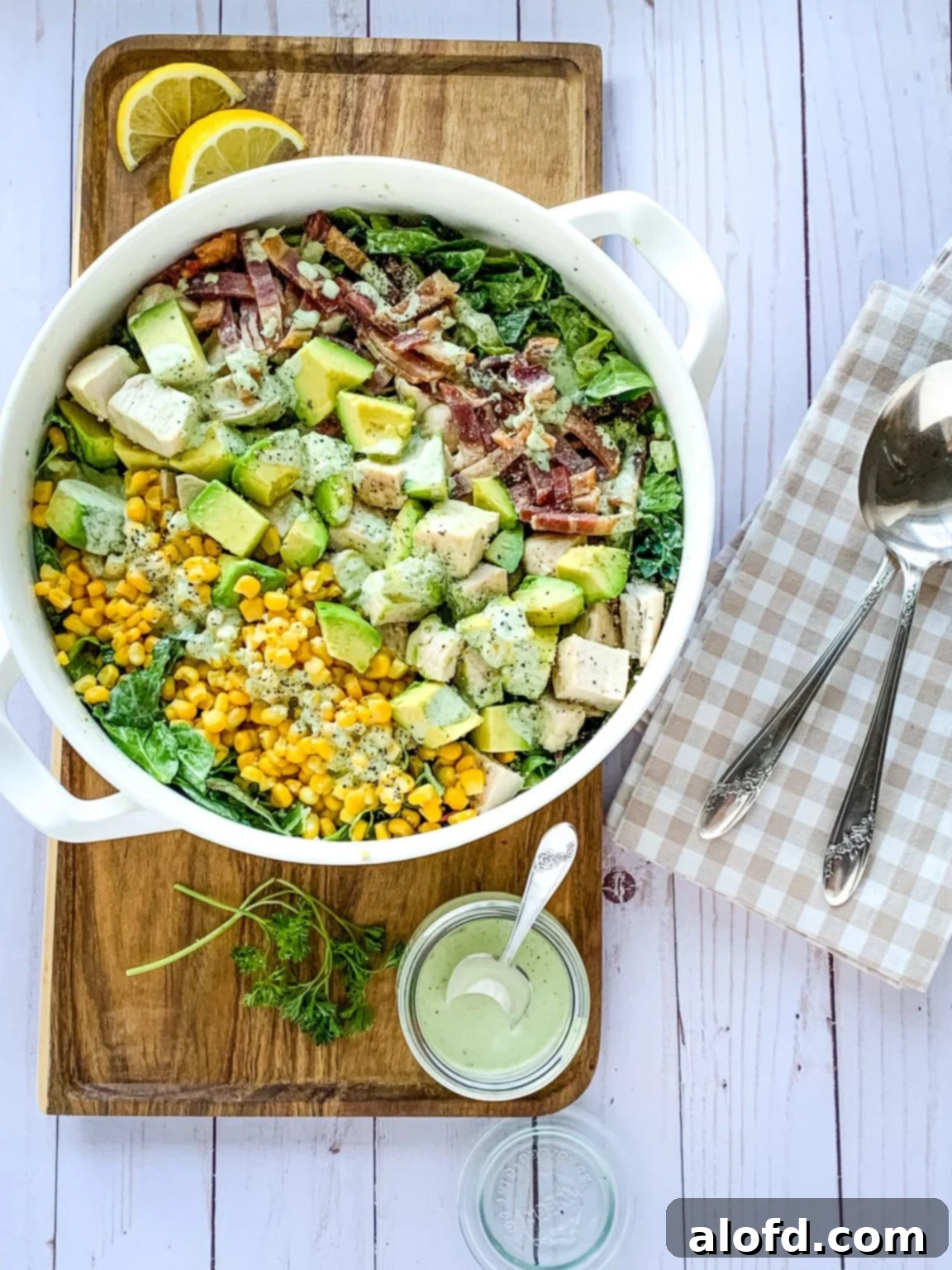 The Ultimate Green Goddess Salad 2 Panera Green Goddess salad in white bowl on a cutting board.