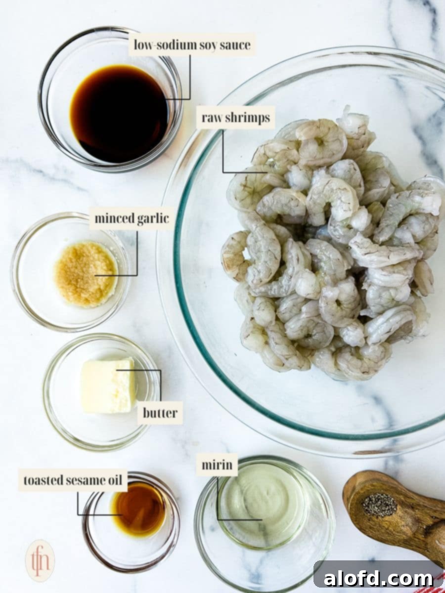 Assortment of fresh ingredients for hibachi shrimp, including shrimp, soy sauce, mirin, and sesame oil, neatly arranged in glass bowls.