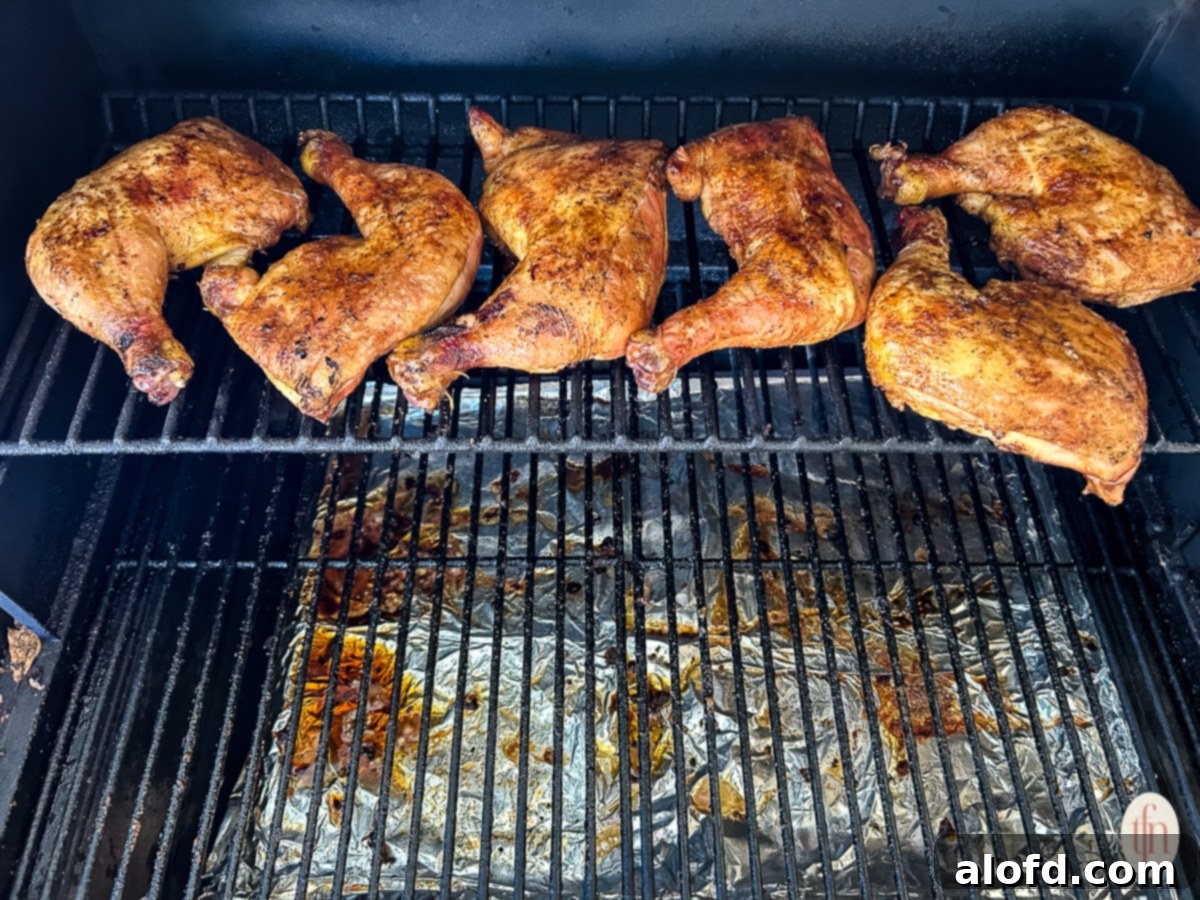 Juicy Smoked Chicken Drumsticks 6 Chicken smoking on the top rack of a smoker, showing the gentle cooking process.