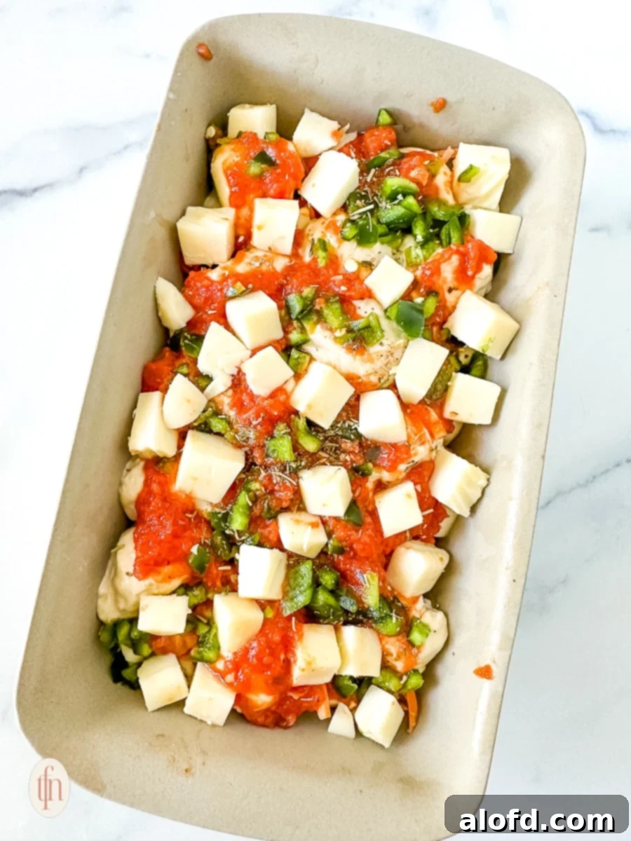 Shortcut Monkey Bread with Frozen Dough 11 One unbaked layer of pizza casserole rising in a baking dish, covered with plastic wrap.