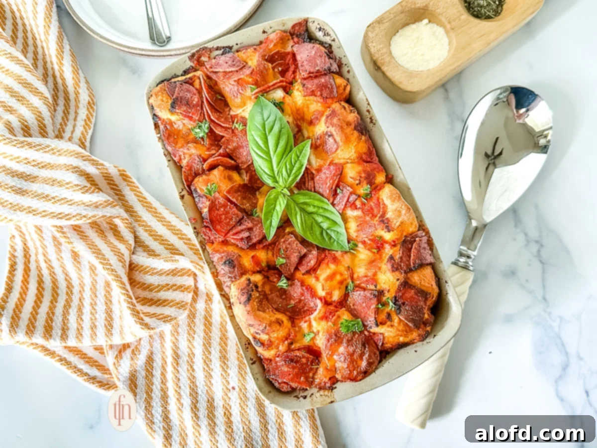 Shortcut Monkey Bread with Frozen Dough 3 Baked pizza pull-apart bread garnished with fresh basil, served in a loaf pan, ready to be enjoyed.