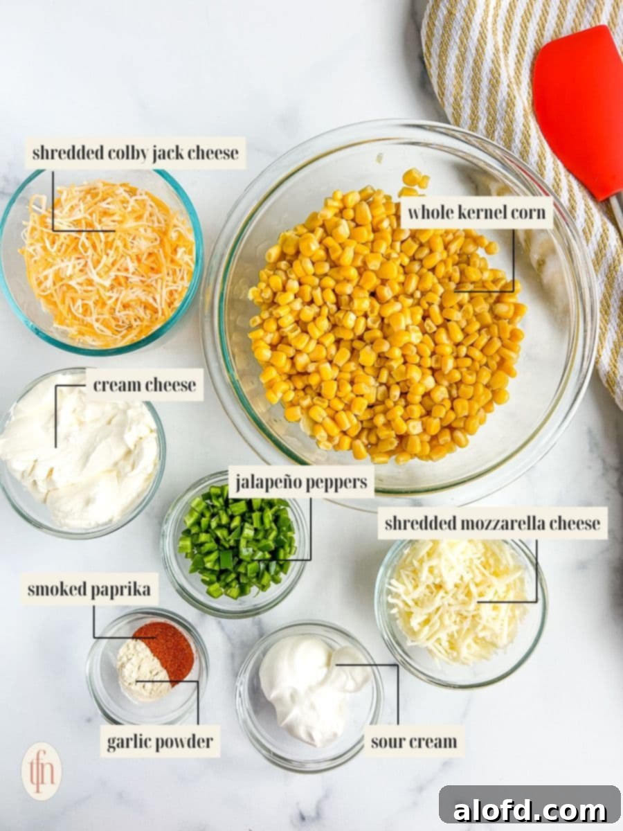 Close-up of neatly arranged ingredients for cream cheese corn dip, including corn, cream cheese, sour cream, cheeses, and jalapeños.