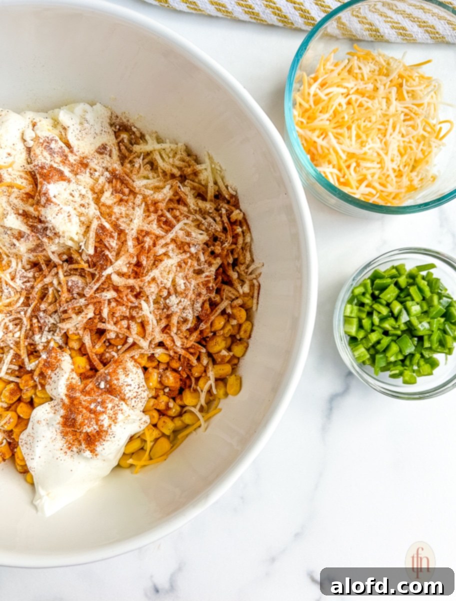 Large mixing bowl with drained corn kernels, ready for other ingredients to be added.