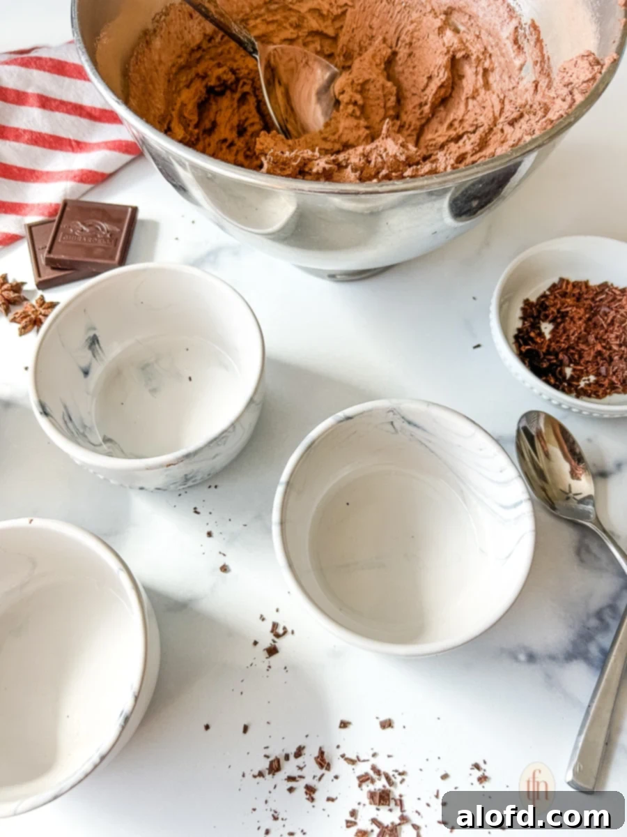Simple Decadent Chocolate Mousse 11 A bowl of mousse and three empty ramekins.