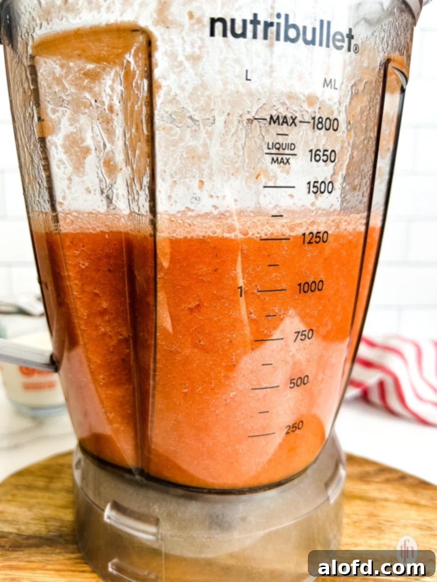 The Ultimate 3-Ingredient Tomato Soup 5 A blender filled with a smooth, vibrant red tomato mixture, ready to be cooked into 3-ingredient tomato soup.