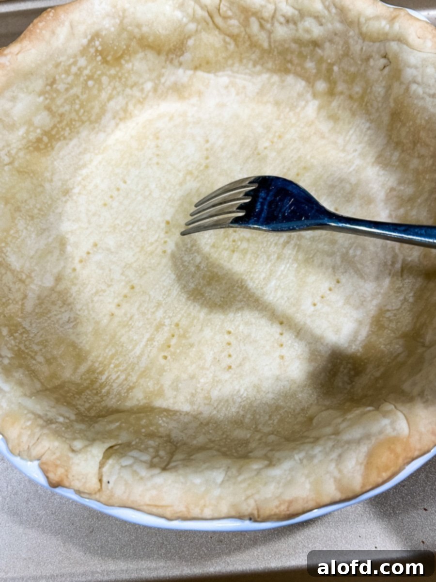 Fork piercing holes in a pastry crust.