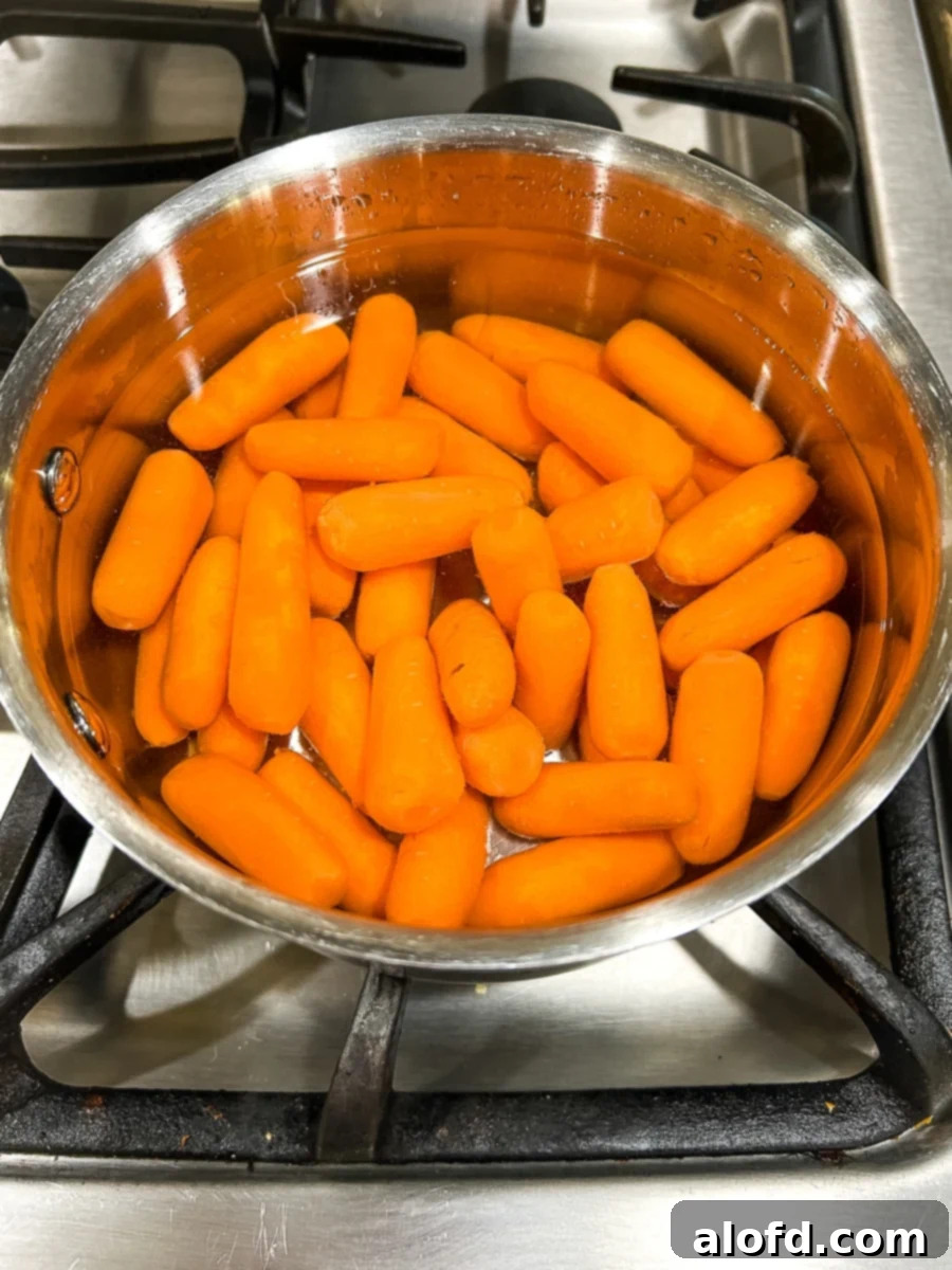 Baby carrots heating up in a pot of water.
