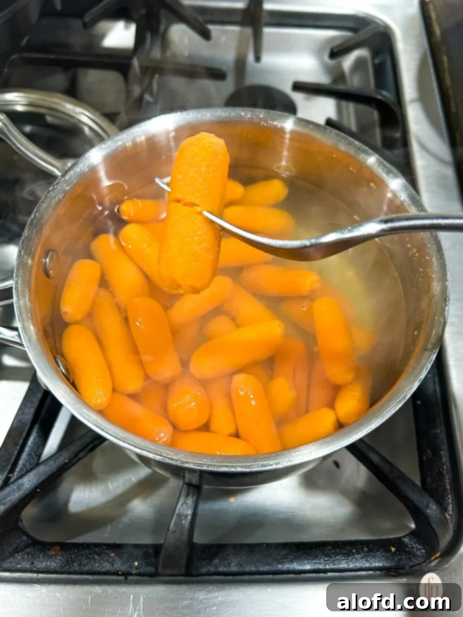 Carrots cooking in a pot on the stove.
