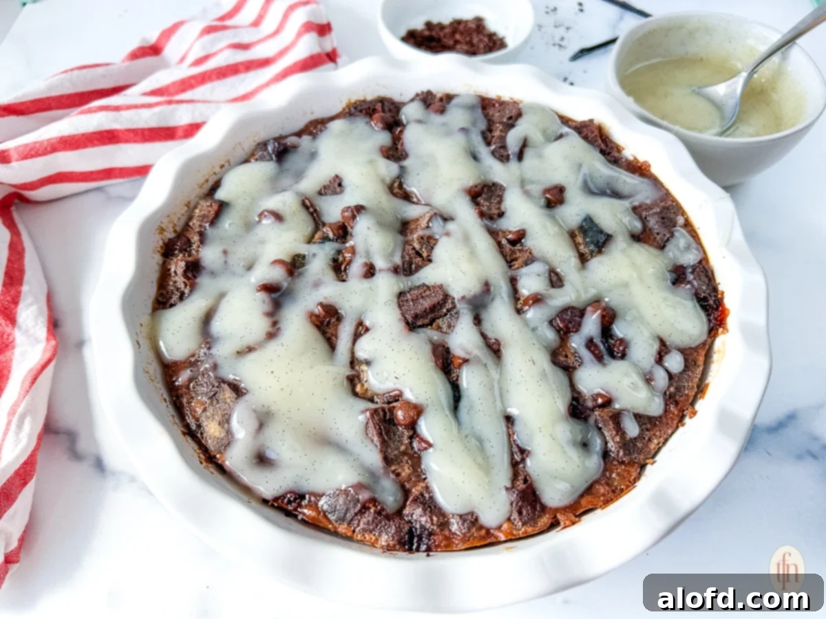 Horizontal image of chocolate sourdough bread pudding in a white bowl, ready to be served.