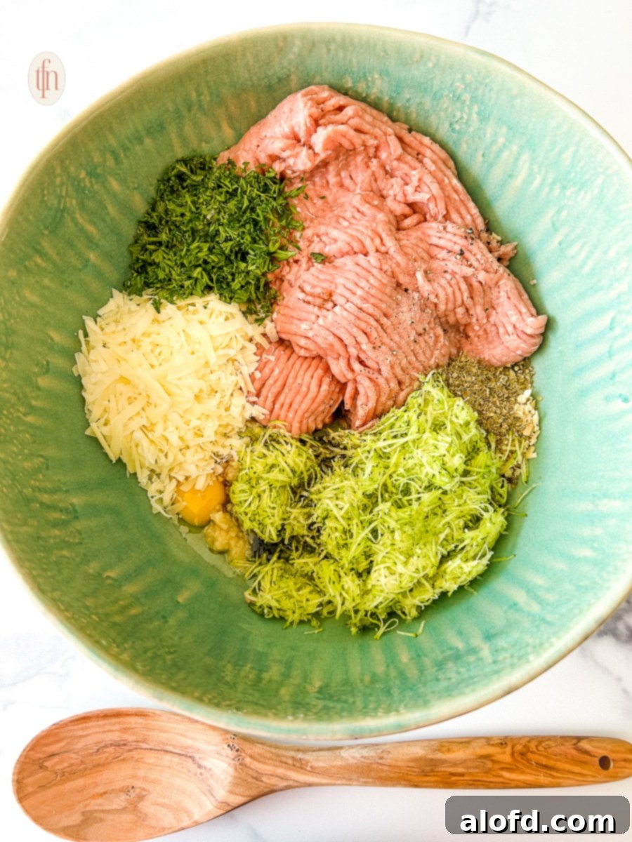All ingredients for zucchini meatballs in a large bowl, ready for mixing.