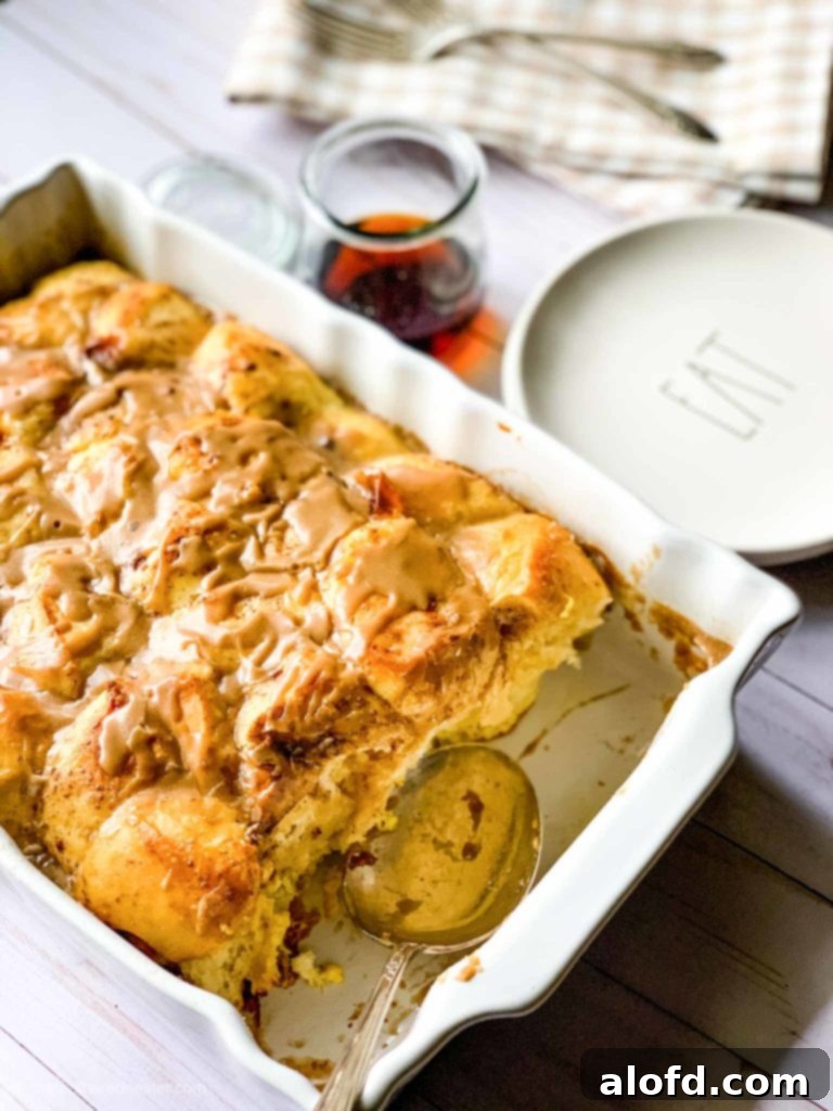 Effortless Overnight French Toast Bake 2 Golden-brown French Toast Casserole, generously topped with a sweet, creamy white icing glaze, ready to serve in a casserole dish. Perfect for a holiday breakfast.