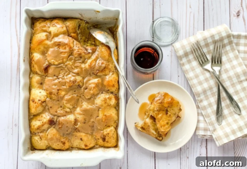 Effortless Overnight French Toast Bake 3 A golden-brown baked French Toast Casserole in a ceramic dish, garnished with powdered sugar and berries, a perfect holiday breakfast.