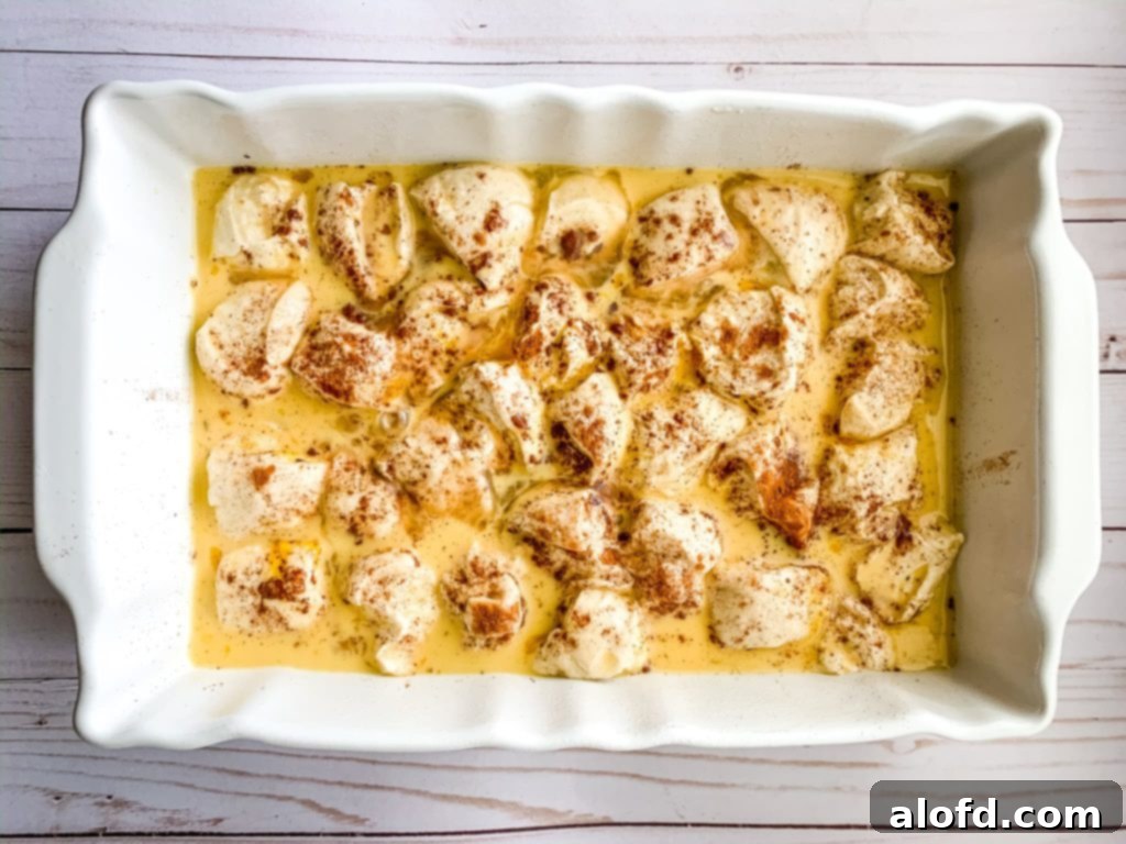 Effortless Overnight French Toast Bake 8 An unbaked breakfast French Toast Casserole in a baking dish, made with frozen dough, eggs, and milk, covered with plastic wrap, ready for overnight refrigeration.