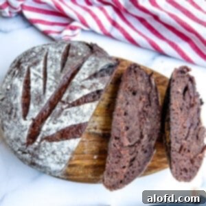 Decadent Chocolate Sourdough 12 Sliced chocolate sourdough bread on a cutting board, showcasing a tender crumb filled with chocolate chips.
