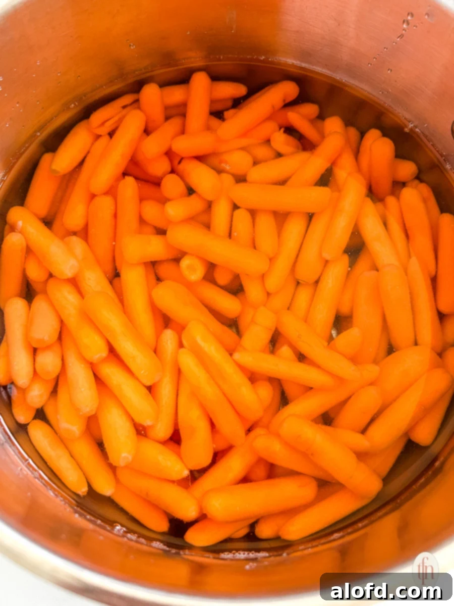 Golden Carrot Bake 5 Carrots boiling in a pot of water on the stove, a crucial first step for the sweet carrot casserole recipe.