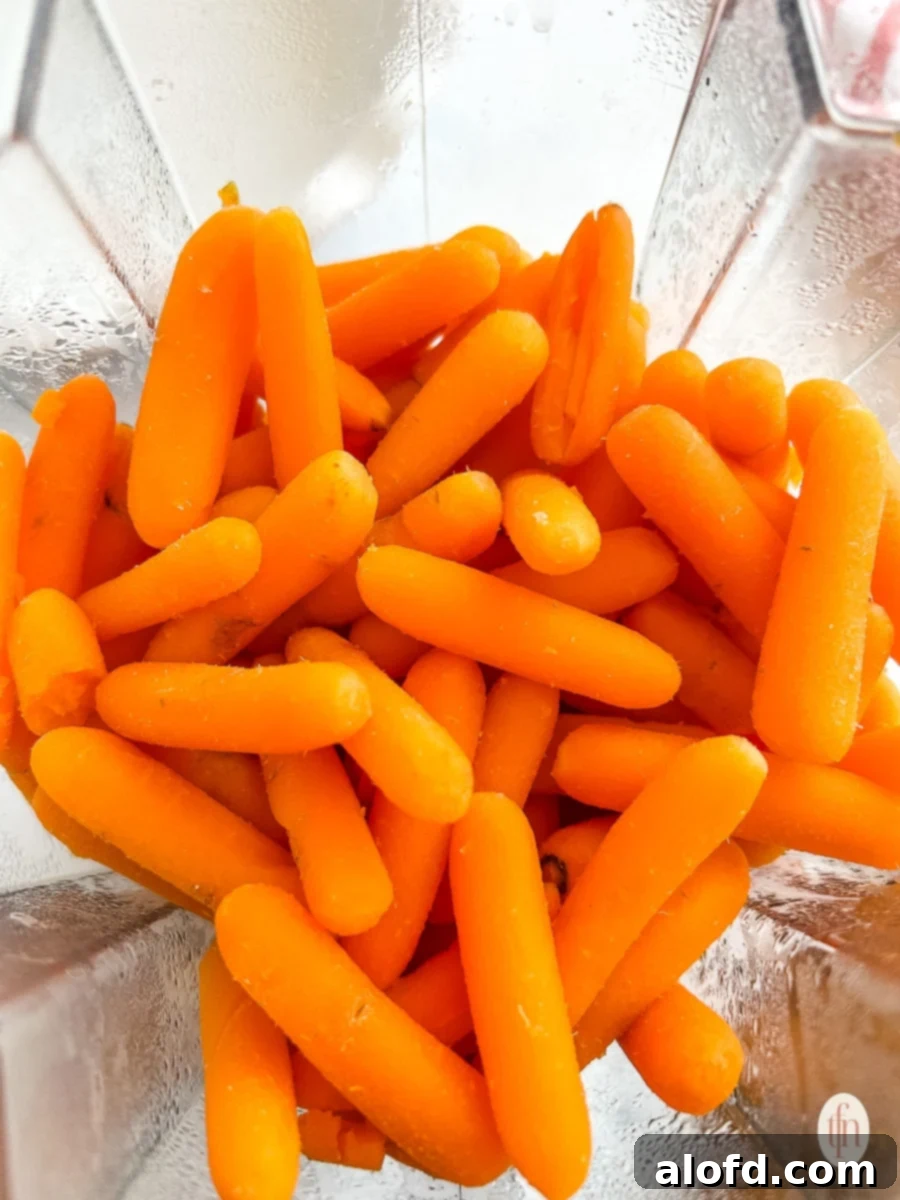 Golden Carrot Bake 6 Baby carrots being blended in a food processor, a key step in creating the smooth filling for the sweet carrot casserole.