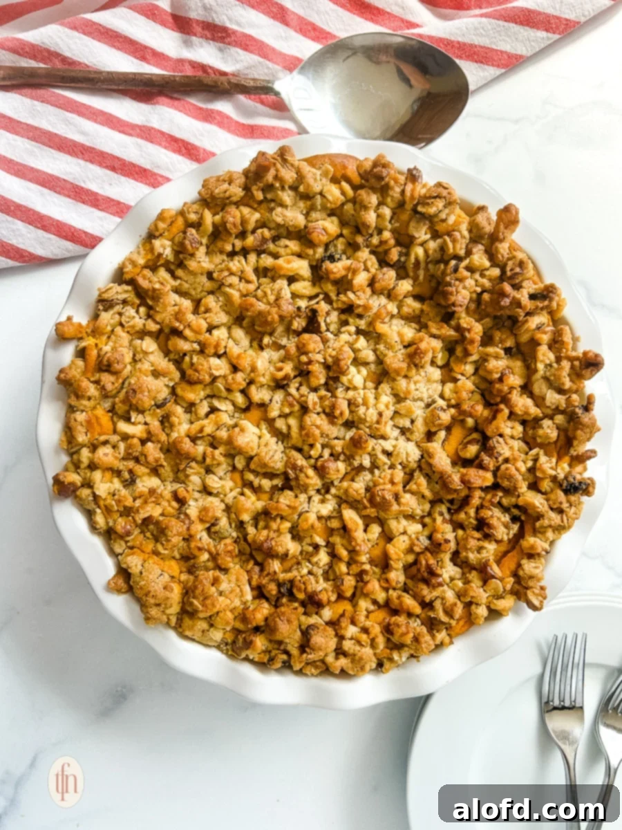Golden Carrot Bake 8 A freshly baked sweet carrot casserole, topped with a golden oat and walnut crumble, served in a white baking dish, ready to be enjoyed.