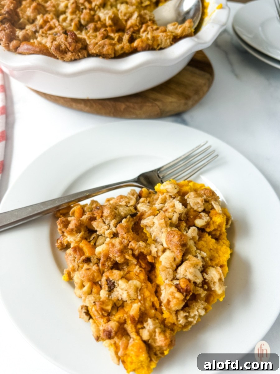 Golden Carrot Bake 9 A single serving of sweet carrot casserole on a white plate with a fork, showing the creamy interior and crunchy topping, ready to be eaten.