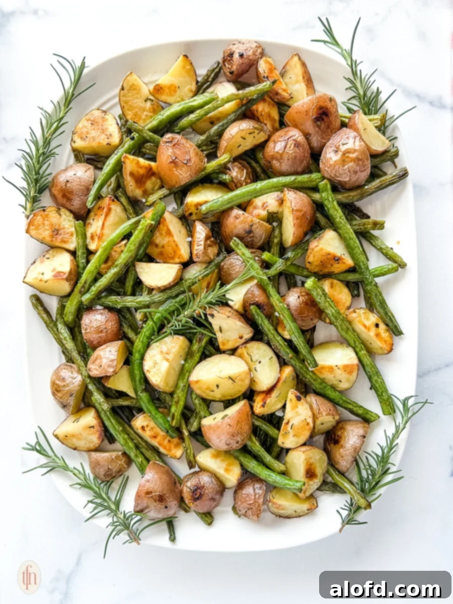 Garlic Herb Roasted Green Beans and Potatoes 2 Platter of perfectly roasted green beans and potatoes on a white background, inviting and fresh.