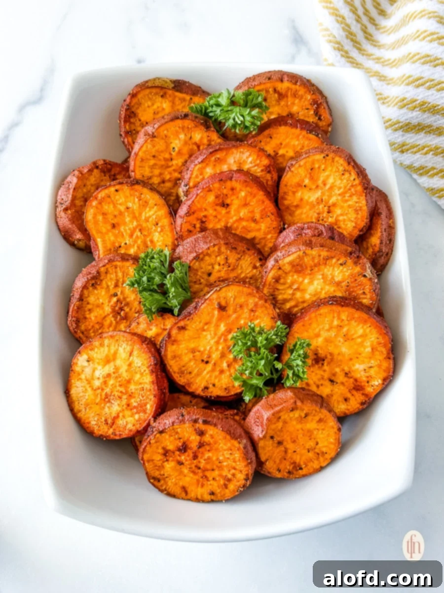 Baked potato slices in a white serving platter, looking golden and inviting.