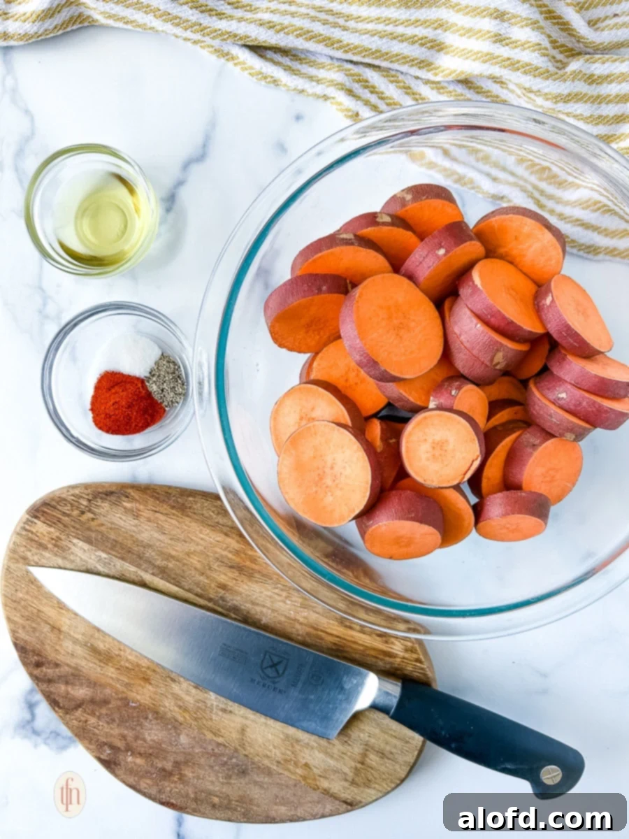 Bowls of prepped ingredients, including sliced sweet potatoes, olive oil, and spices, alongside a knife and cutting board.