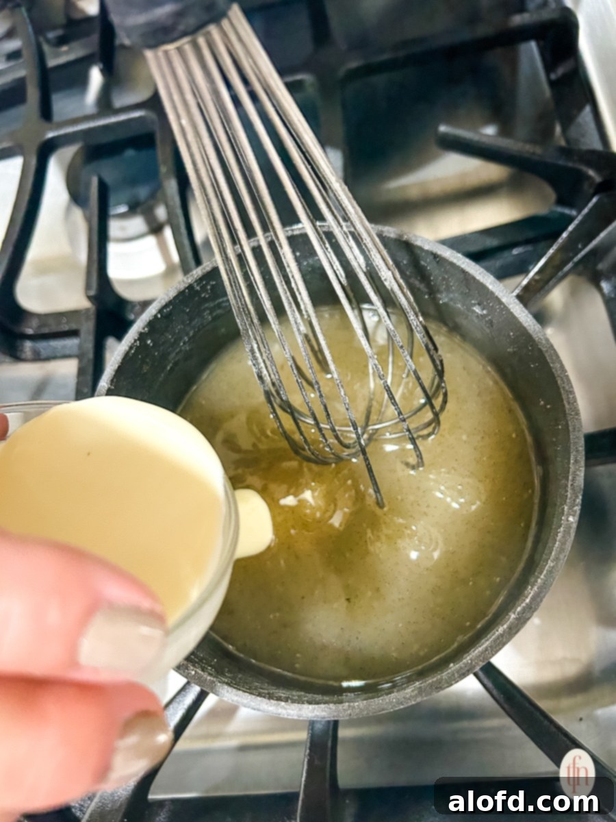 Velvety Vanilla Sauce for Bread Pudding 7 Pouring cream into pot of vanilla sauce.