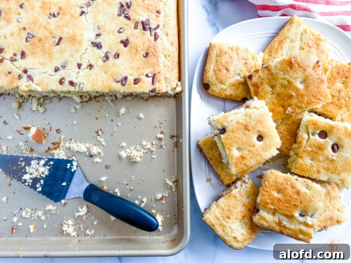 Effortless Sheet Pan Pancakes from Mix 10 A stack of golden brown sheet pan pancakes on a white plate, ready to be drizzled with syrup and enjoyed.