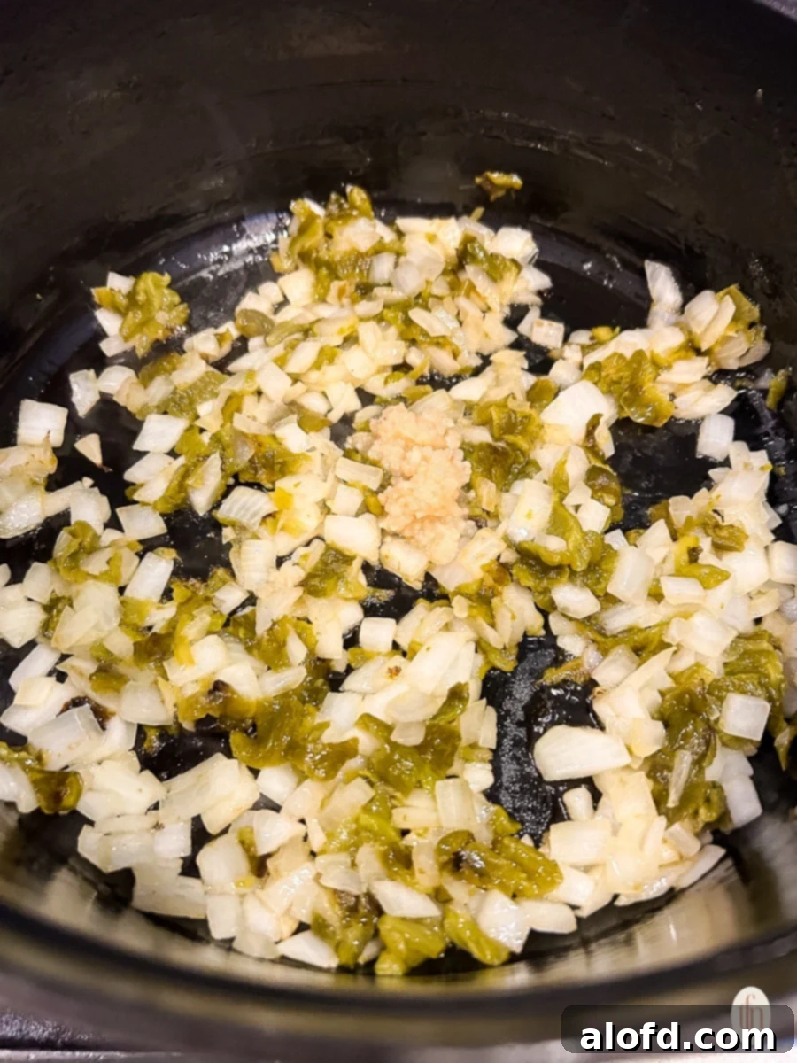 Ingredients sautéing in a pot on the stove. 