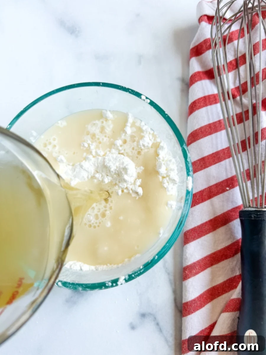 Pouring broth into cornstarch.