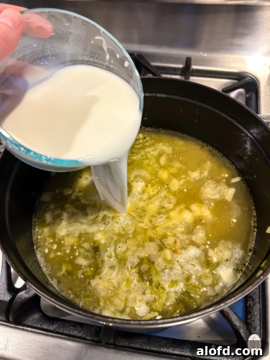 Adding the cream to the jalapeno soup.