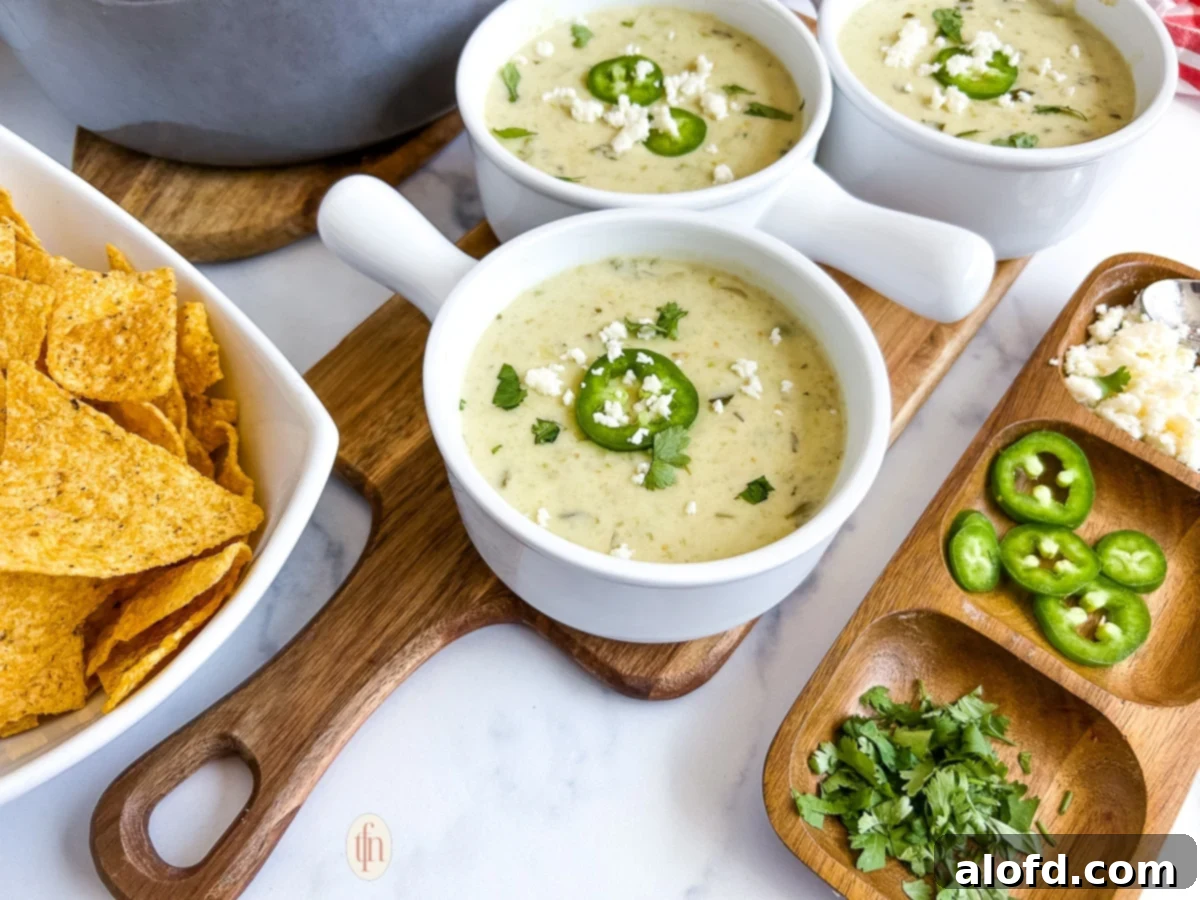 Three bowls of cream of jalapeno soup next to toppings.