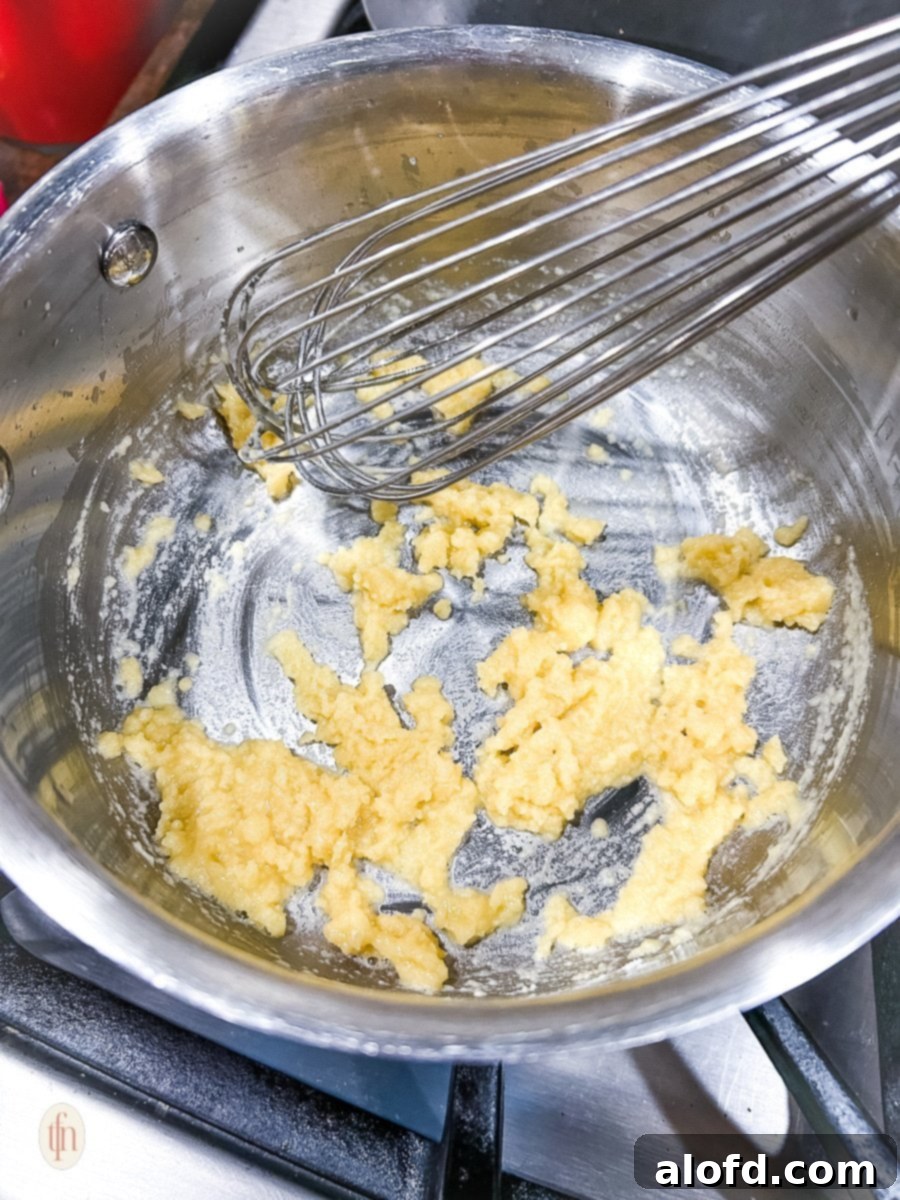 Voodoo Kitchen Fries 5 Whisking butter and flour together in a saucepan to create a roux, a crucial step for a smooth sauce base.